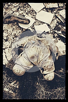 Body of a headless doll in a distressing environment