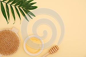 Body honey massage, ingredients for spa treatments at home on a yellow background. Dry brush massage.