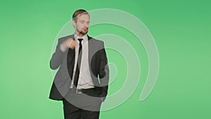 Body language. a man in a business suit on a green background, hromakey, dancing