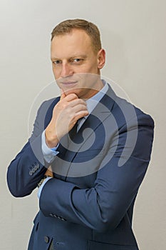Body language. man in business suit stroking the chin