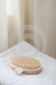 Body massage brush on white towel. body care product natural materials, zero waste, spa body care concept. Eco-friendly