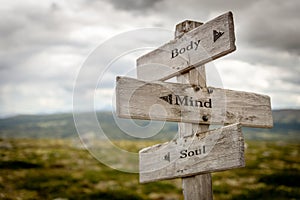 body mind soul text engraved on old wooden signpost outdoors in nature