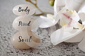 Body, Mind and Soul text engraved on white zen stones Meditation and spa concept