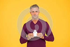 Body odor care. Handsome man hold lotion or bodywash bottle. Presenting personal hygiene care product. Shampoo or gel photo