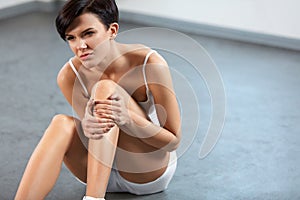 Body Pain. Beautiful Woman With Painful Knee, Feeling Leg Pain