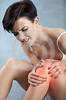 Body Pain. Beautiful Woman With Painful Knee, Feeling Leg Pain