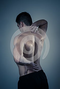 Body Pain. Strong young man suffering neck and back pain