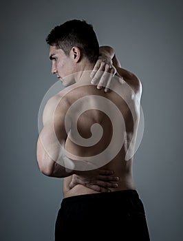 Body Pain. Strong young man suffering neck and back pain