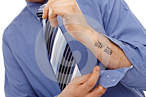 Body part of businessman with tattoo in forearm