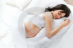 Body Pillow. Pregnant Woman Sleeping On Pregnancy Pillow On Bed