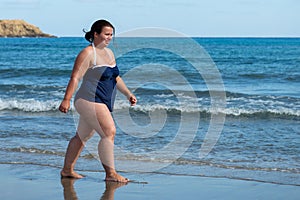 Body positive. Happy fat woman on the beach