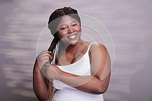 Body positive woman braiding long hair with ombre effect