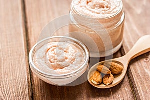 Body scrub with almonds for body care on wooden table background