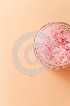 Body scrub of sea salt with lemon, rosemary and olive oil in glass jar on stone table, homemade cosmetic for Spa care