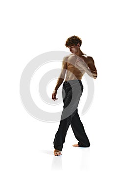 Body size photo of attractive man with curly hair posing against white studio background. Half-naked athletic male model