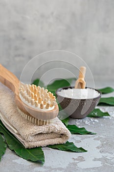 Body spa treatment bamboo brush with bath towel, salt m on green tropical leaf background