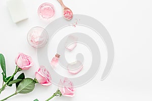 body treatment with rose flowers and cosmetic set white desk background top view space for text