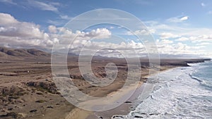 A body of water with a mountain and clouds in the background