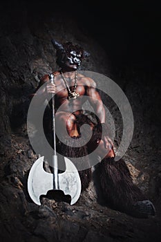 The bodyart man angry minotaur with axe in cave