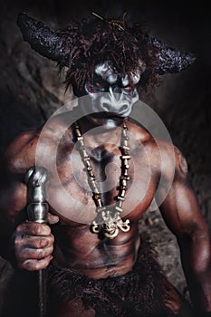 The bodyart man angry minotaur with axe in cave