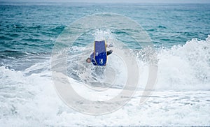 Bodyboarder in action on the ocean waves on a sunny day.