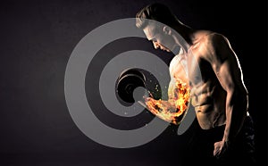 Bodybuilder athlete lifting weight with fire explode arm concept