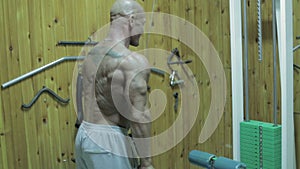 The bodybuilder do exercises for a triceps in the gym.