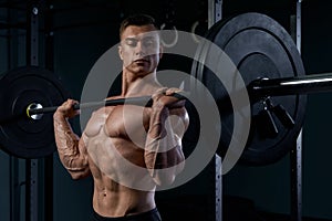 Bodybuilder doing exercise with a barbell at gym