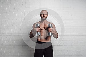 Bodybuilder doing exercises for biceps with a dumbbells against