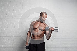 Bodybuilder doing exercises for biceps with a dumbbells against