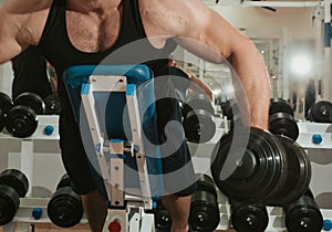 Bodybuilder with dumbbells, trainings in a gym photo