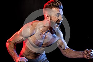Bodybuilder gesturing and yelling isolated on black with dramatic lighting