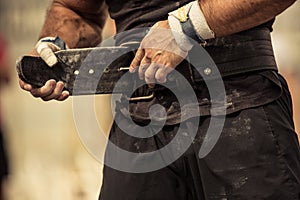 Bodybuilder girding on his bodybuilding belt