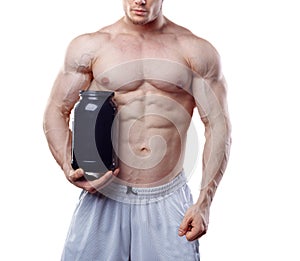 Bodybuilder holding a black plastic jar with whey protein on white background. No face