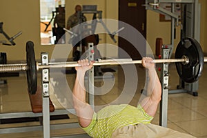 Bodybuilder lifts weights.