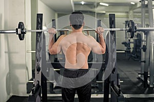 Bodybuilder man with big muscular  back in the gym