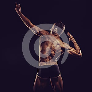 Bodybuilder man posing, showing perfect abs, houlders, biceps, triceps, chest