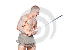 Bodybuilder man posing with a sword isolated on white background. Serious shirtless man demonstrating his mascular body.