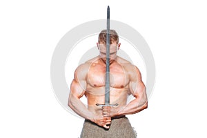 Bodybuilder man posing with a sword isolated on white background. Serious shirtless man demonstrating his mascular body.