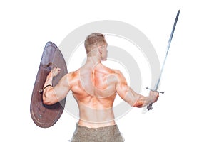 Bodybuilder man posing with a sword and shield isolated on white background. Serious shirtless man demonstrating his