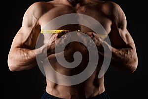 Bodybuilder with a measuring tape around his chest. Nude bodybuilder with a measuring tape around his chest isolated on