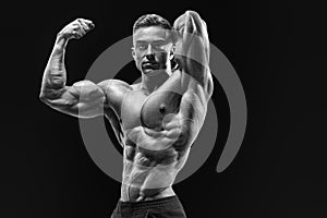 Bodybuilder with muscular physique looking at camera showing bic