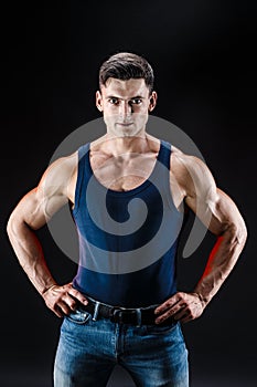 Bodybuilder posing. Beautiful sporty guy male power. Fitness muscled man in shirt.