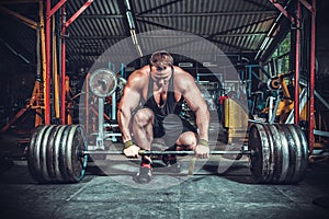 Bodybuilder preparing for deadlift of barbell