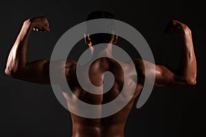 Bodybuilder showing his back and biceps muscles, personal fitnes.Brown-skinned