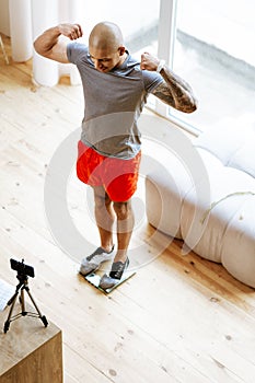 Bodybuilder showing his biceps while standing in front of camera