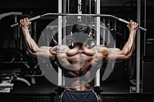 Bodybuilder training back on simulator in the gym