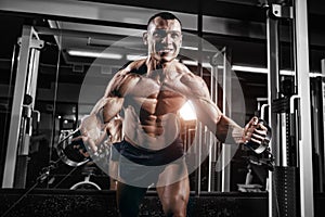 Bodybuilder training chest on simulator in the gym