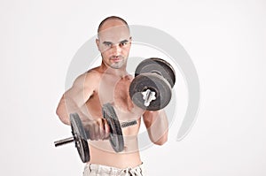 Bodybuilder training hard with heavy dumbbells.