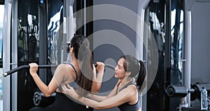 Bodybuilder of women training exercise workout at fitness gym in sportswear with personal trainer